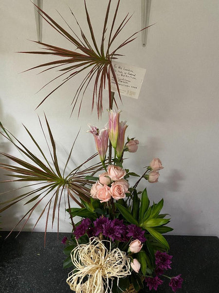 1 dozen Baby pink roses with stargazer in a basket
